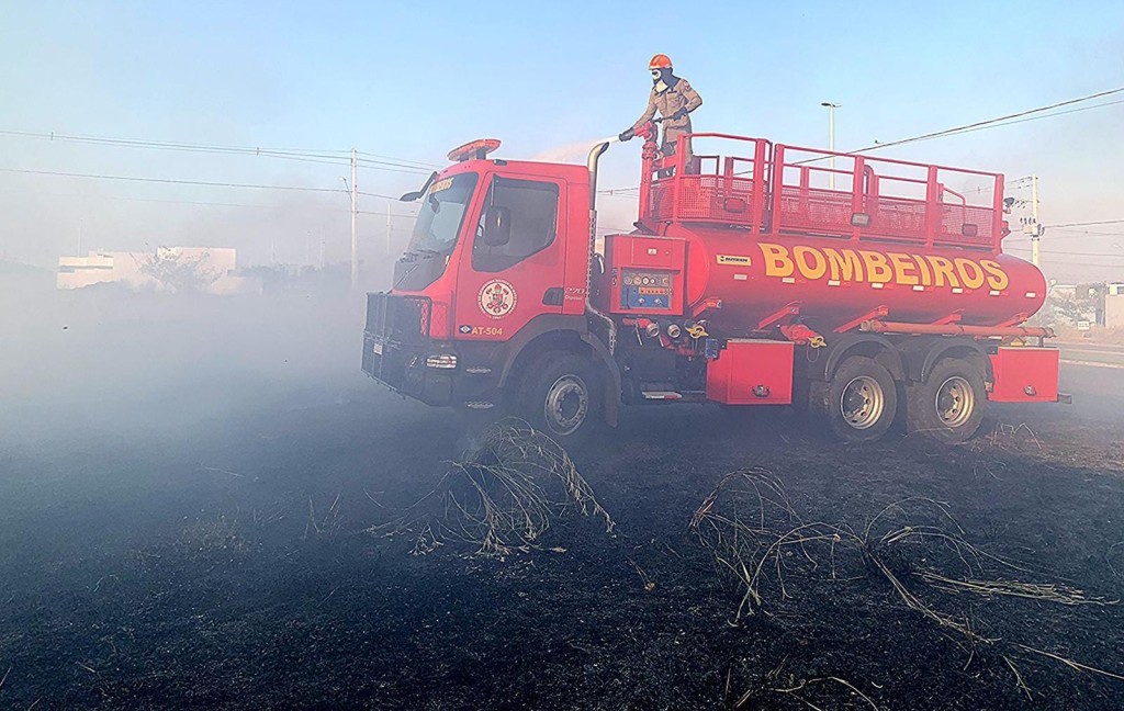Bombeiros combatem incêndio em vegetação de terreno baldio