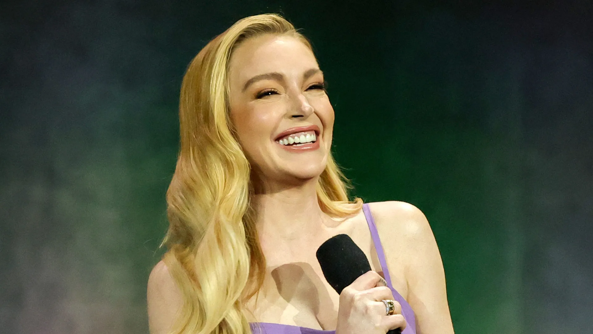 Lindsay Lohan surge radiante com vestido e bolsa Chanel