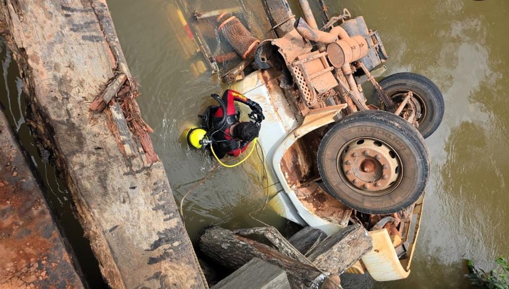 Caminhão com cimento e botijões de gás cai de ponte e mata mulher em zona rural